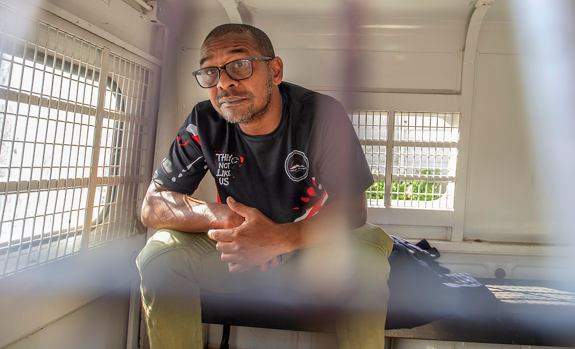 Fadiel Adams at the back of a police van after being arrested.